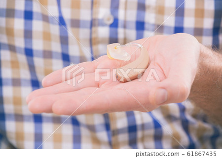 Man showing deaf aids Man showing deaf aids 61867435