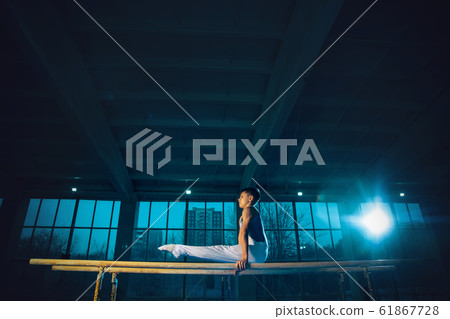 Little male gymnast training in gym, flexible and active 61867728