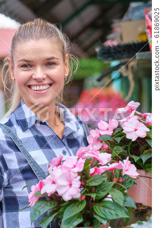 Young woman gardening in greenhouse.She selecting Young woman gardening in greenhouse.She selecting 61869025
