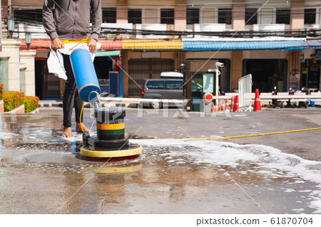 Woman worker using scrubber machine for cleaning polishing concrete floor. Woman worker using scrubber machine for cleaning polishing concrete floor. 61870704