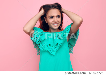 A frustrated irritated girl aggressively holds her 61872725