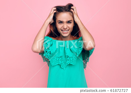 A frustrated irritated girl aggressively holds her 61872727