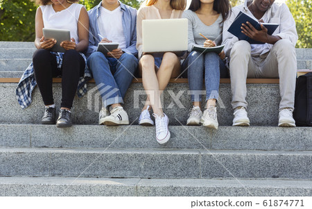 Cropped of international students doing homework on the street Cropped of international students doing homework on the street 61874771