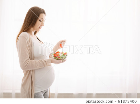 Pregnant lady enjoying fresh natural vegetable salad Pregnant lady enjoying fresh natural vegetable salad 61875400
