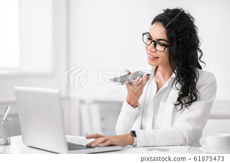 Mexican businesswoman using mobile voice recognition function Mexican businesswoman using mobile voice recognition function 61875473