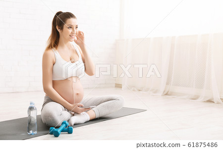 Pregnant woman talking on phone after yoga 61875486