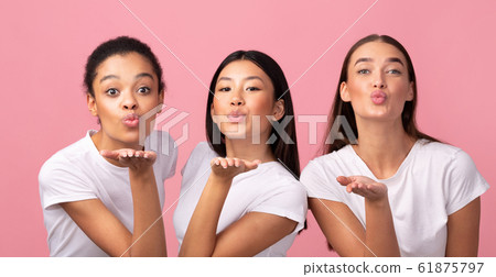 Three Millennial Girls Sending Air Kiss Posing Over Pink Background 61875797