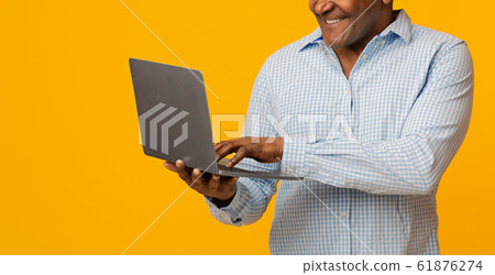 Mature african man typing on laptop, panorama 61876274