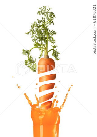 Falling slices of cut carrot to a glass of juice. Falling slices of cut carrot to a glass of juice. 61876321
