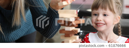 Young mum with little daughter play game in wood block Young mum with little daughter play game in wood block 61876666