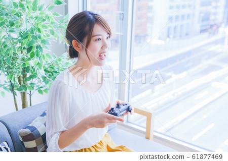 A woman enjoying a game at a home party Japanese lifestyle living salon matching room 61877469