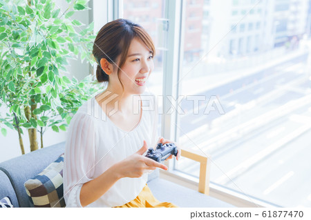 A woman enjoying a game at a home party Japanese lifestyle living salon matching room 61877470