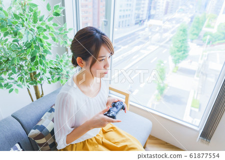 A scene where a housewife enjoys a game for a change of character A person model A female game controller Living 61877554