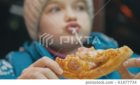 Child eat pizza cheese four. Close up of young girl woman eating pizza and chewing in outdoor restaurant. Kid children hands taking piece pizza. Child eat pizza cheese four. Close up of young girl woman eating pizza and chewing in outdoor restaurant. Kid children hands taking piece pizza. 61877734