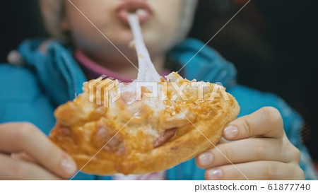 Child eat pizza cheese four. Close up of young girl woman eating pizza and chewing in outdoor restaurant. Kid children hands taking piece pizza. 61877740