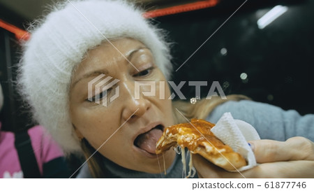 Girl eat pizza cheese four. Close up of young woman mouth greedily eating pizza and chewing in outdoor restaurant. Junk food. Pizza from open box. Girl eat pizza cheese four. Close up of young woman mouth greedily eating pizza and chewing in outdoor restaurant. Junk food. Pizza from open box. 61877746
