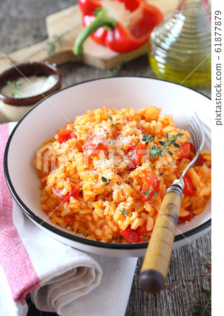 Italian cuisine. Plate of red bell pepper risotto, olive oil and parmesan cheese Italian cuisine. Plate of red bell pepper risotto, olive oil and parmesan cheese 61877879