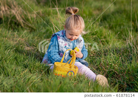 Small girl collects chocolate eggs for Easter Small girl collects chocolate eggs for Easter 61878114