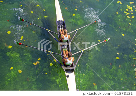 Two young athletes rowing team on green lake Two young athletes rowing team on green lake 61878121
