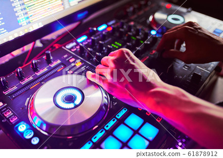 Dj mixes the track in the nightclub at a party Dj mixes the track in the nightclub at a party 61878912