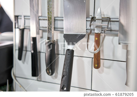 Set of knives on magnetic holder in the kitchen. Restaurant Set of knives on magnetic holder in the kitchen. Restaurant 61879205