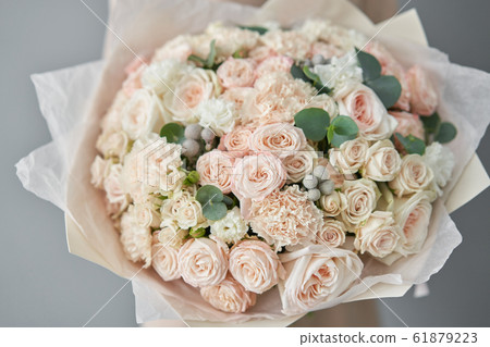European floral shop. Beautiful bouquet of mixed flowers in womans hands. the work of the florist at a flower shop. Delivery fresh cut flower. European floral shop. Beautiful bouquet of mixed flowers in womans hands. the work of the florist at a flower shop. Delivery fresh cut flower. 61879223