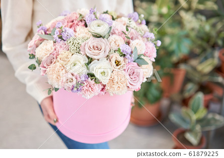 European floral shop. Floral bunch in round box. Bouquet of beautiful Mixed flowers in woman hand. Excellent garden flowers in the arrangement , the work of a professional florist. European floral shop. Floral bunch in round box. Bouquet of beautiful Mixed flowers in woman hand. Excellent garden flowers in the arrangement , the work of a professional florist. 61879225