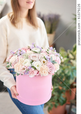 European floral shop. Floral bunch in round box. Bouquet of beautiful Mixed flowers in woman hand. Excellent garden flowers in the arrangement , the work of a professional florist. European floral shop. Floral bunch in round box. Bouquet of beautiful Mixed flowers in woman hand. Excellent garden flowers in the arrangement , the work of a professional florist. 61879226