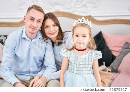 Loving family Mom and dad, little daughter . Parents and baby child having fun. Merry Christmas and Happy New Year. Cheerful pretty people. Loving family Mom and dad, little daughter . Parents and baby child having fun. Merry Christmas and Happy New Year. Cheerful pretty people. 61879227