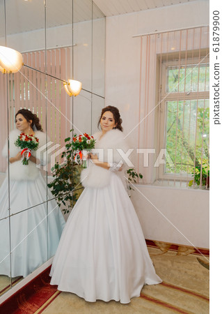 Beautiful happy bride in a room with a wedding Beautiful happy bride in a room with a wedding 61879900