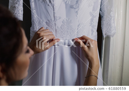 Beautiful happy bride touches her wedding dress. 61880559