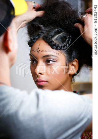 beautiful Latin American model with the assistance of a stylist preparing for a photoshoot 61882442