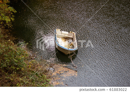 Abandoned small boat and lake Abandoned small boat and lake 61883022