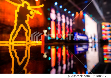 Blurred background of an esports event - Main stage venue, big screen and lights before the start of the tournament. 61883170