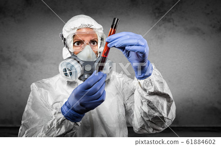 Woman In Hazmat Suit and Gas Mask Holding Test Tube Woman In Hazmat Suit and Gas Mask Holding Test Tube 61884602