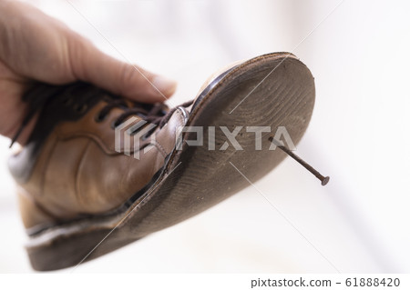 The back of a shoe stuck with an iron nail 61888420