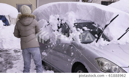 A woman who can remove snow from a car 61888962