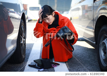 Woman looking for car key in parking lot 61890340