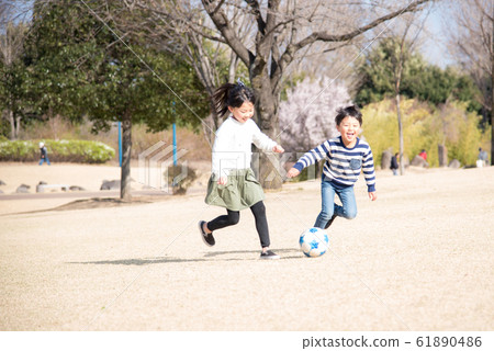 A child playing soccer with a smile 61890486