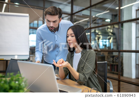 Two employees working in the office and looking interested 61890943