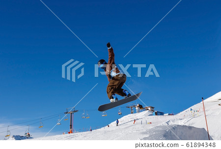 Male snowboarder against the blue sky Male snowboarder against the blue sky 61894348