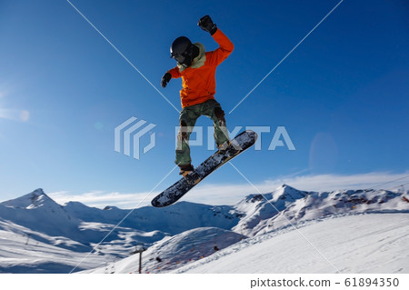 Snowboarder against the blue sky 61894350