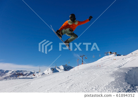 Snowboarder does a jumping trick in the snow Park Snowboarder does a jumping trick in the snow Park 61894352