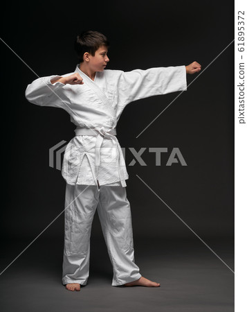 a teenager dressed in martial arts clothing poses 61895372
