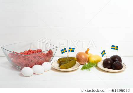 Ingredients for a traditional Swedish dish beef Lindstrom. Freshly minced beef, boiled potato, white chopped onion, pickles, pickled red beets, eggs. Swedish cuisine. Scandinavian Ingredients for a traditional Swedish dish beef Lindstrom. Freshly minced beef, boiled potato, white chopped onion, pickles, pickled red beets, eggs. Swedish cuisine. Scandinavian 61896053