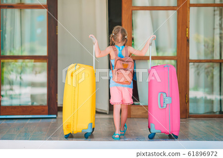 Adorable little girl with luggages ready for traveling Adorable little girl with luggages ready for traveling 61896972