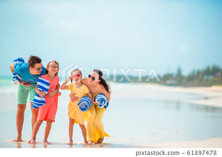 Young family of four on beach vacation 61897478