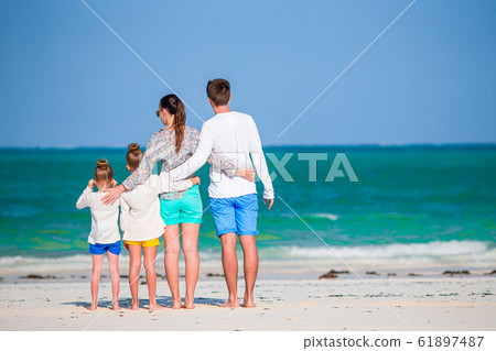Happy beautiful family of four on the beach Happy beautiful family of four on the beach 61897487