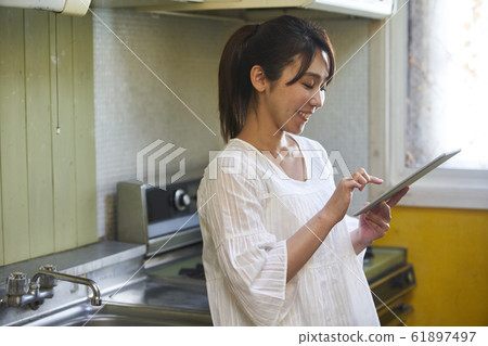 Portrait of young woman standing in the kitchen 61897497