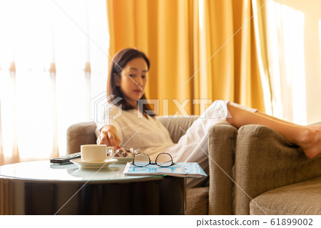 Coffee and document paper snack on table with woman in background. 61899002